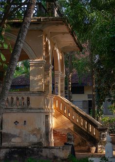 an old gazebo in the middle of a park with stairs leading up to it