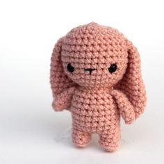 a pink crocheted stuffed animal sitting on top of a white surface