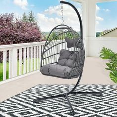 a swing chair on a porch with a black and white rug