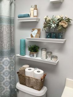 a bathroom with two shelves above the toilet