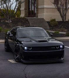 a black sports car parked in front of a building with steps leading up to it