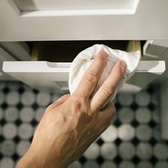 a hand holding a napkin in front of a stove