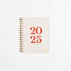 a spiral notebook with the number twenty five printed on it, sitting on a white surface