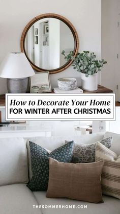 a living room with white couches, pillows and a round mirror on the wall