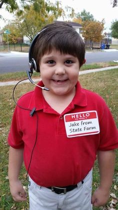 a young boy wearing a headset with a name tag on his shirt that says hello