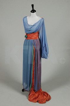 An unusual orientalist evening gown, circa 1913, the blue chiffon over-dress edged in large coral glass beads, single long sleeve, coral damask back bodice, waist sash with silk flowers and train, underskirt of jade green chiffon, together with a navy chiffon Paquin bodice, Winter 1912, London-Paris label no 51354, of midnight blue and ivory satin, chiffon and lace (2) Paquin Fashion, Jeanne Paquin, Fashion 1910, 1910s Fashion, Edwardian Dress, 20th Century Fashion, Waist Sash, Old Dresses, Vintage Gowns