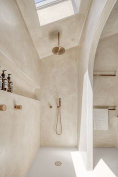 a bathroom with a skylight above the bathtub and shower head is shown in this image