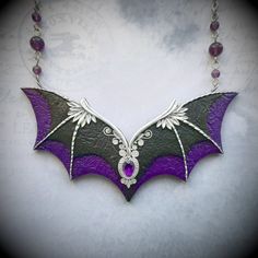 This statement purple and black Gothic bat wings necklace is hand-sculpted of polymer clay and decorated with amethyst gem. Would be perfect for a Halloween witch outfit. Necklace length - 20 inches Bib height - 2 inches Bib width - 4.25 inches Can be made in different colors and sizes - please feel free to contact me if you need a special piece. Handmade Purple Fantasy Necklaces, Handmade Purple Fantasy Necklace, Gothic Purple Necklace For Halloween, Black Fantasy Jewelry For Costume, Black Fantasy Costume Jewelry, Fantasy Black Costume Jewelry, Gothic Purple Jewelry For Halloween, Fantasy Style Amethyst Purple Jewelry, Fantasy Style Purple Amethyst Jewelry