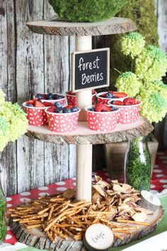 a dessert table with strawberries and french fries on it, next to a sign that says forest berries