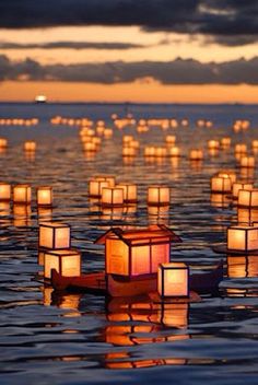 lanterns floating in the water at sunset