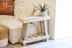 a white couch sitting next to a wooden table with a potted plant on it