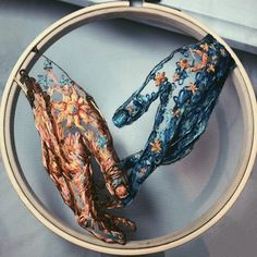 two hands that are made out of fabric in a circular frame on a blue background