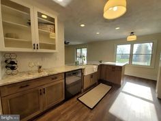 an empty kitchen with wooden floors and cabinets