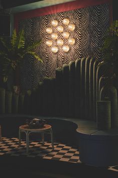 a black and white checkered floor in front of a wall with lights on it