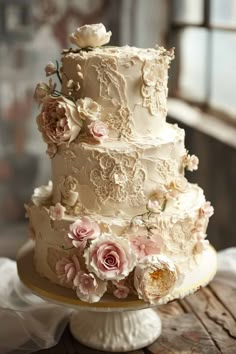 a three tiered wedding cake with pink flowers on the side and white icing