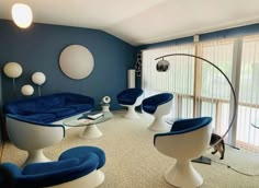 a living room with blue and white furniture in the middle of carpeted flooring