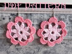 two crocheted flower earrings hanging from hooks with the words do it yourself written above them