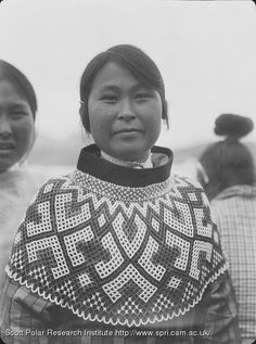 an old black and white photo of two women wearing crocheted shawls, with one woman standing behind her