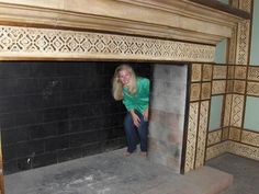 a woman sitting on the floor in front of a fireplace