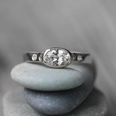 a diamond ring sitting on top of a rock