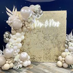 balloons and flowers are arranged in front of a backdrop