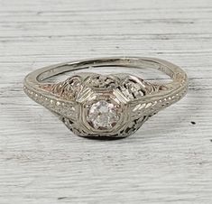 "L-1944  Antique Art Deco Filigree Diamond 18K White Gold Ring 8.25 Luxury Design Pretty  AMAZING ANTIQUE PERIOD ART DECO FILIGREE SOLID 18K GOLD RING. NATURAL DIAMOND, ALL ORIGINAL. WEAR ALONE ON WITH YOUR STACK. WONDERFUL COLOR & HIGHEST QUALITY. JUST PART OF MY MOST RECENT ESTATE FINDS! FOLLOW ME TO SEE THEM ALL!    Metal: 18K White Gold Metal Purity: 18K Material: Diamond Ring Size: 6 Other Dimensions: 3/8\"w Form: Ring Luxury Age: Antique Weight (Grams): 2.6 IT IS IN EXCELLENT ESTATE CONDITION  ALL ITEMS LISTED AS GOLD ARE EITHER MARKED AND OR TESTED FOR CONTENT  TO HELP DETERMINE SIZE / SCALE OF PIECE THE QUARTER IS PICTURED AND MEASURES 24.16mm OR .95 INCHES    PLEASE DON'T BE AFRAID TO SEND AN OFFER, I AM NEVER OFFENDED & I LOVE GIVING DEALS!  The pictures are of the the actual ite Vintage Engraved Diamond Ring For Formal Occasions, Classic Filigree Ring With Polished Finish For Formal Events, Classic Filigree Ring With Polished Finish For Formal Occasions, Elegant Ceremonial Diamond Ring, Elegant Formal Engraved Hallmarked Ring, Antique Engraved Ring With 17 Jewels For Wedding, Classic Formal Engraved Ring With 17 Jewels, Classic Engraved Ring With 17 Jewels For Formal Occasions, Vintage Engraved Ring With Intricate Design For Formal Occasions