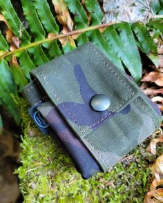 a wallet sitting on top of moss covered ground