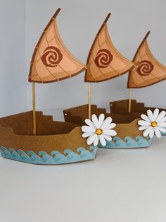 two paper boats with white flowers on them