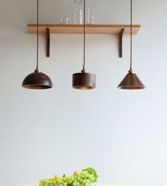 three lights hanging over a table with grapes