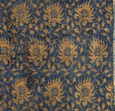 an old blue and gold rug with flowers on it