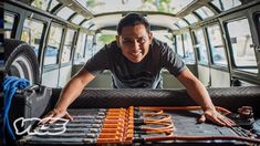 a man standing in the back of a bus with lots of tools