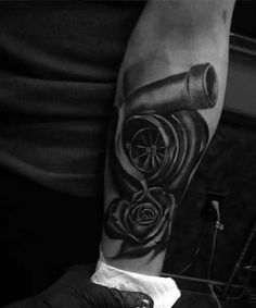 a black and white photo of a man's arm with a tattoo on it