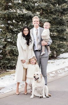 a man, woman and child posing for a photo with their dog