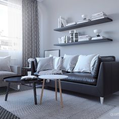 a living room with black leather couches and white pillows on top of the sofa