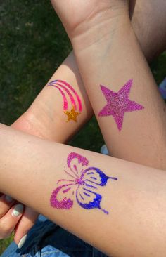 this pin shows three glitter tattoos on a group of peoples' arms. One tattoo is a pink star, one is a blue and pink butterfly, the last is a shooting star with a gold star and pink ombre lines. Shimmer Tattoos, Glitter Tattoo Designs, Glitter Tattoo Aesthetic, Small Glitter Tattoo, Stand Glitter, Glitter Tattoo Summer, Sparkly Tattoo, Diy Glitter Tattoos, Glitter Tatoos