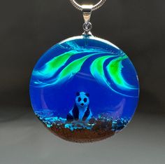 We love watching the magnetic dance of the northern lights. It's a great feeling to reflect this on our necklaces. We placed a three-dimensional tiny panda inside, completely hand-painted. I can customize this necklace for you. The pendant is combined with a piece of exotic wood and resin. This necklace is a great gift for those who love the aurora borealis. The necklace has an excellent shine. The necklace is absolutely unique and it is impossible to make a new piece exactly like it. This will Luminous Pendant Necklace For Gift, Unique Luminous Jewelry As A Gift, Unique Luminous Jewelry For Gifts, Tiny Panda, Wood Resin Necklace, Wood Resin Jewelry, Beautiful Wooden Boxes, Anniversary Necklace, Special Birthday Gifts