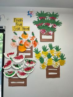 the wall is decorated with paper plates and fruit on them, which are cut out to look like pineapples