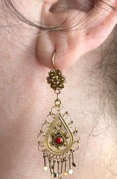 "A beautiful and elaborate pair of vintage cannetille earrings. These outstanding earrings are made of buttery 10k yellow gold (not marked but acid tested positive) and are crafted with fine cannetille wirework. Each earring is comprised of a two-dimensional link that is intricately layered and hangs from a decorative surmount. Delicate beadwork, twisted rope wirework, and swirled floral accents decorate the earrings and fringed accents dangle freely from the bottom. The surmounts have a complim Vintage Jewelry With Intricate Design For Celebrations, Vintage Jewelry For Celebration With Intricate Design, Antique Gold Dangle Jewelry With Intricate Design, Vintage Earrings With Intricate Design For Anniversary, Historical Design Drop Earrings As Gift, Victorian Filigree Jewelry For Ceremonial Occasions, Ornate Brass Earrings For Celebration, Antique Filigree Jewelry For Celebrations, Historical Drop Earrings Jewelry Gift