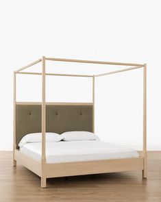 a bed that has a white sheet on top of it and is in a room with wood floors