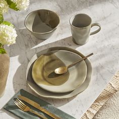 a table setting with goldware and flowers