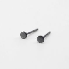 A pair of dot earrings with a black oxidized finish. * Diameter approx. 3 mm or 0.19 inch * Sterling silver earrings posts and butterfly backs * Made of silver with a dark oxidized finish. Over time of actively wearing the piece, the dark color fades and transforms into a beautiful antique silver shade Please note, that our handmade jewellery is unique so items may vary slightly from the pictures. All our products are designed and made by us in our workshop in the Lithuanian countryside. Every piece of jewelry comes carefully and beautifully packed in a branded craft paper box, gift ready. You might also like these bigger dots: https://www.etsy.com/listing/1045559981/black-dots-5-mm-silver-earrings-oxidised Feel free to contact us if you have any questions via Etsy messages or e-mail pucin Lithuanian Countryside, Earrings Oxidised, Black Studs, Dot Earrings, Black Stud, Round Stud Earrings, Dark Color, Black Dots, Fun Earrings