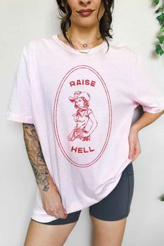 RAISE HELL COUNTRY COWGIRL WESTERN OVERSIZED GRAPHIC TEEPREMIUM COTTONOVERSIZED FIT Trendy Pink T-shirt With Front Print, Pink Relaxed Fit Top For Streetwear, Pink Cotton T-shirt With Funny Print, Pink Short Sleeve Shirt With Funny Print, Retro Pink Top With Funny Print, Pink Cotton Crew Neck Shirt, Pink Graphic Print Crew Neck Top, Pink Graphic Tee Cotton Top, Casual Pink Shirt With Funny Print