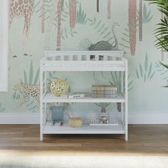 a baby's room with a giraffe wallpaper and jungle mural on the walls