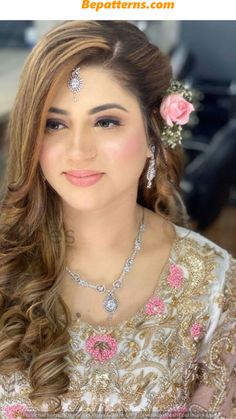 a woman with long hair wearing a flower in her hair and jewelry on her head