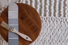 a paint brush sitting on top of a wooden board next to a swatch of paint