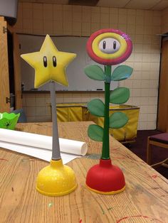 some paper flowers are on a table with other items in the room behind them that look like they have been made out of construction material