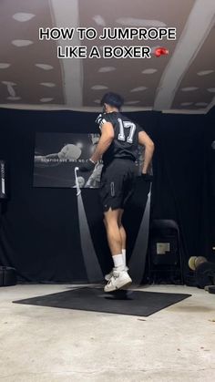 a man standing on top of a black mat in front of a sign that says how to jump rope like a boxer