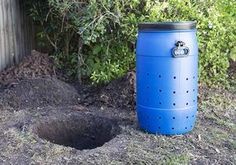 a blue trash can sitting in the dirt