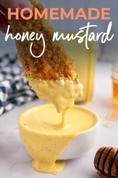 honey mustard is being drizzled over the top of a small bowl filled with honey