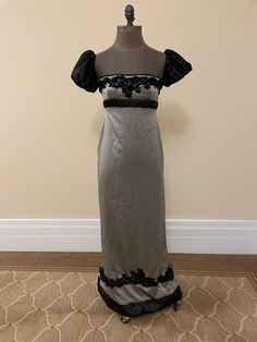 Beautiful Regency inspired evening gown, with empire waist and beautiful puffed sleeves. The dress is made of silver and black silk, with beautiful black lace trim at the bust and hem. Please note, this dress is not meant to be historically accurate, but historically inspired.   *100% silk  * Entire dress is lined  *Zipper closure  *All seams finished  *Dry clean only  *Free standard shipping included!         If you have any questions about this dress, or are interested in  a different size, please message  me.  Thank you! Measurements:   Bust:   34-35" Underbust: 30-32" Dress Underbust to Hem: 42.5" Hips: 36-37.5" Biceps: 11" (these are not elastic cuffs) Please note, the  measurement can be slightly adjusted if needed! Gothic Regency Dress, Empress Waist Dress, Regency Dress Black, Elegant Victorian Satin Dress For Costume, Elegant Empire Waist Costume Dress, Elegant Fitted Evening Dress For Costume, Black Regency Dress, Elegant Victorian Dress With Empire Waist For Costume, Black Victorian Dress With Fitted Bodice For Evening